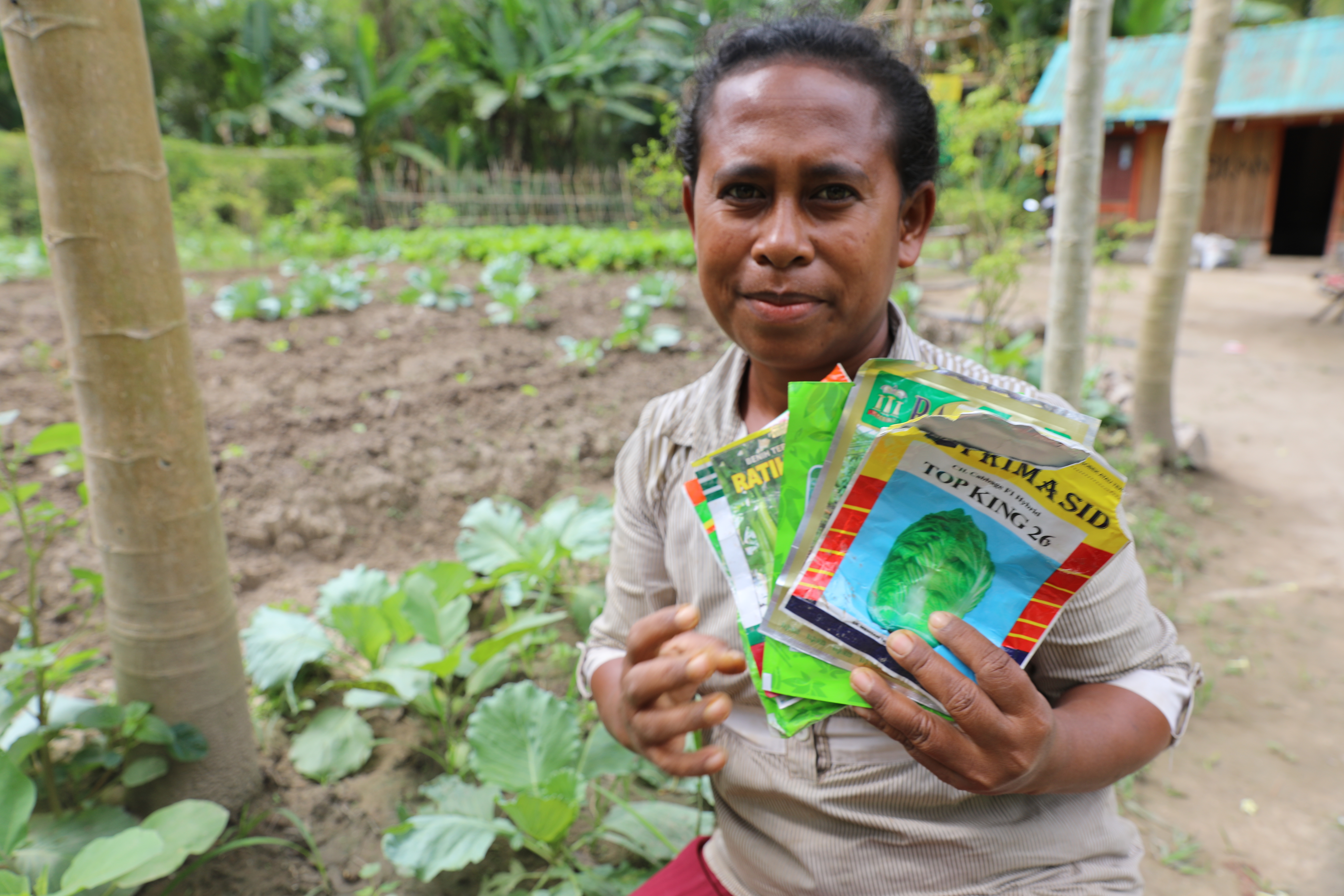 Yuliana holding her seed packets in the communal garden